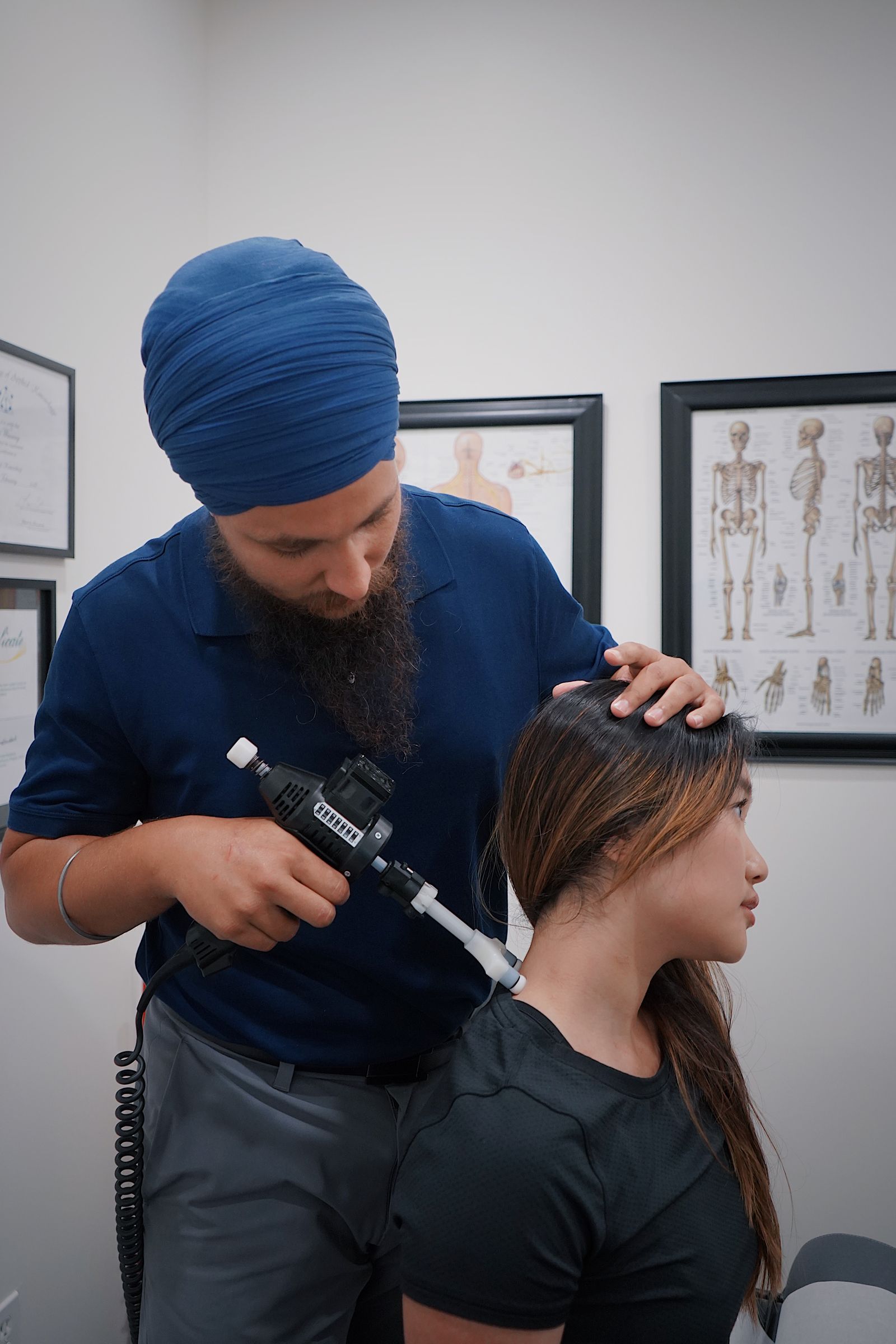 Chiropractor treating a patient's neck with an adjustment tool
