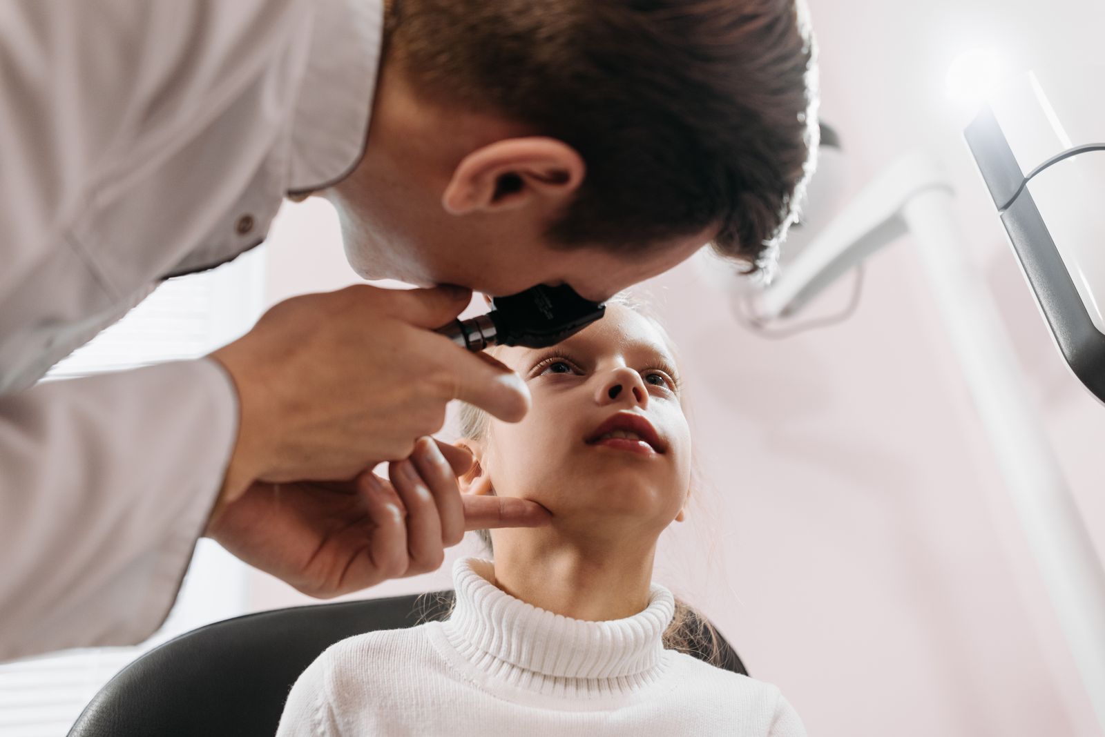 Doctor examining a young girl's eye during a checkup