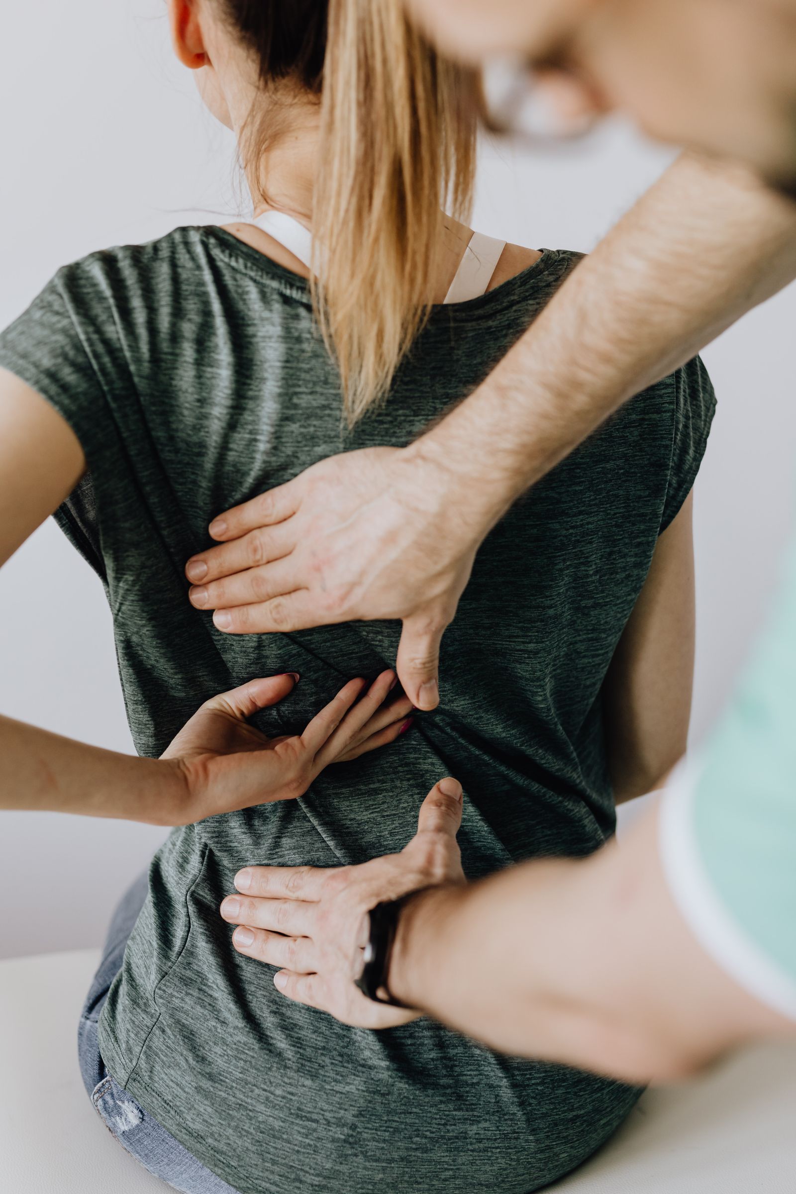 Practitioner examining a patient's back for pain